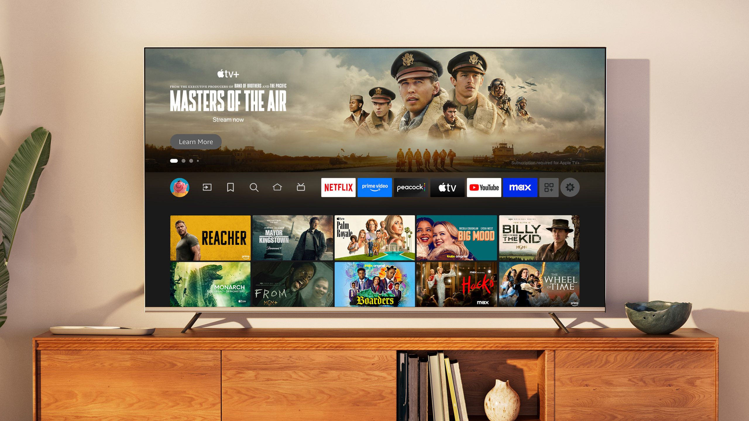A close shot of a TV in a living room during the day. The Fire TV main menu is on screen, with Masters of the Air as the selected title. 